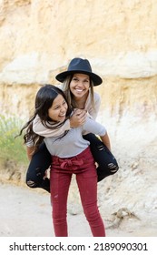 Girl Giving Woman A Piggy Back Ride, Having Fun 