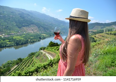 Girl With A Glass Of Wine Looking To The Vineyards In Douro Valley, Portugal