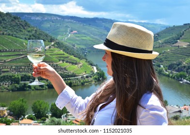 Girl With A Glass Of Wine Looking To The Vineyards In Douro Valley, Portugal