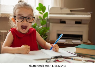 Girl in glasses for sight. A happy little girl opened her mouth with joy while learning lessons. Left-handed. International left-handed day. - Shutterstock ID 1766425415