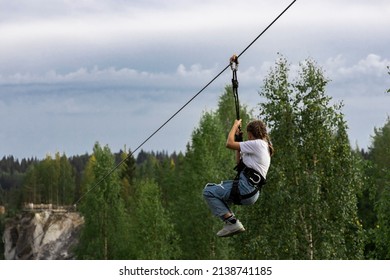 Girl Gliding  In  Road Trolley Zipline In The Mountain Park. 