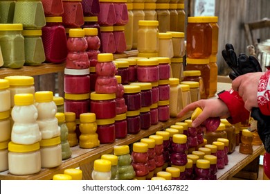 Girl With Gloves Chooses Honey And Sweets On The Counter In Winter