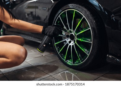 
A Girl In Gloves Uses Car Chemicals To Clean The Rims Before Washing The Car