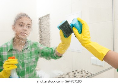 Girl In Gloves Washes A Mirror In The Bathroom. Cleaning Concept. Housewife Work