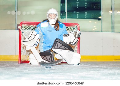 Girl goaltender crouches in crease to protect net - Powered by Shutterstock