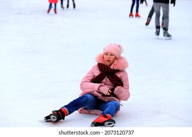 The Girl Goes Ice Skating And Falls On Children's Ice Rink. Sports Injury, Leg Pain, Fracture During Sports Activities, Winter Break. Dnipro, Dnepropetrovsk, Ukraine, 2020-02-09