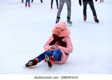 The Girl Goes Ice Skating And Falls On Children's Ice Rink. Sports Injury, Leg Pain, Fracture During Sports Activities, Winter Break. Dnipro, Dnepropetrovsk, Ukraine, 2020-02-09