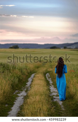 girl goes on a field road