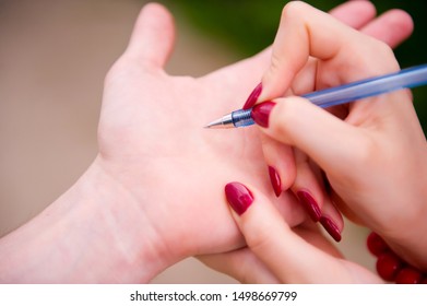 The Girl Is Going To Write To The Guy On His Hand Her Phone Number With A Blue Pen, Close Up