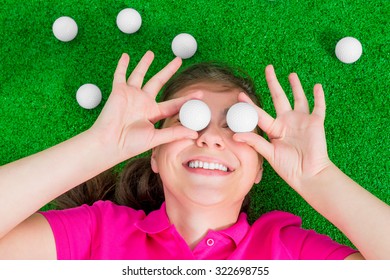 girl with golf balls before his eyes laughing lying on the grass