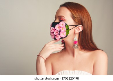 Girl With Gorgeous Long Hair In An Antiviral Mask. Fashion Photo On The Cover Of The Magazine. Pandemic, Virus, Coronavirus, Masked Girl Spring Has Come. Spring Fashion, Model In A Mask Of Flowers