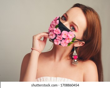 Girl With Gorgeous Long Hair In An Antiviral Mask. Fashion Photo On The Cover Of The Magazine. Pandemic, Virus, Coronavirus, Masked Girl Spring Has Come. Spring Fashion, Model In A Mask Of Flowers