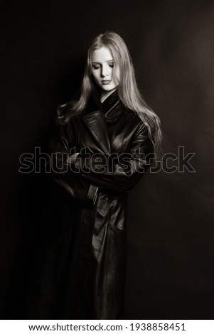 Girl Gothic with long hair on a dark background. Model with in a black leather coat. Beautiful model, leather clothes.Woman Black and White Beauty Portrait.Young beautiful  Woman .Girl in black.Gothic