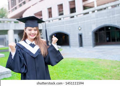 Girl gratuate smile with fist gesture happily at campus 
