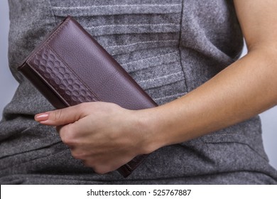 Girl in a gray dress holding a brown purse - Shutterstock ID 525767887
