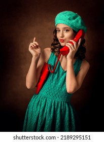 A girl in a green dress and a green beret is talking on a red phone. The girl is flirting. Pin Up. Retro.