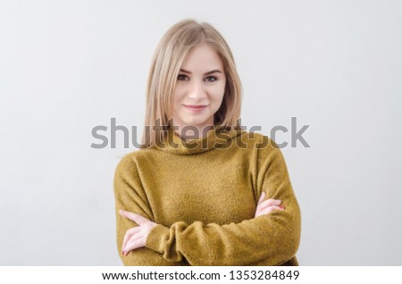 Girl in a green sweater posing on white background.