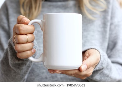 Girl in grey sweater holding white coffee mug , white porcelain 15 oz mug mock up
