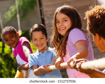 Girl In Group Of Diverse Kids Pull Rope Play Game