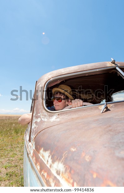 a girl and guy in old rusty\
car