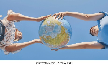 A girl and a guy swivels a globe of the world. The concept of peace and creation. - Powered by Shutterstock