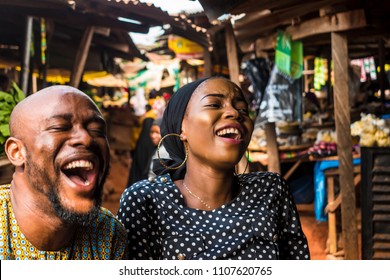 A Girl And A Guy In A Typical African Local Market Laughing 