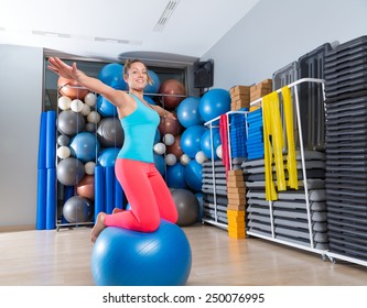 Girl at gym swiss ball knee balance drill exercise workout open arms - Powered by Shutterstock