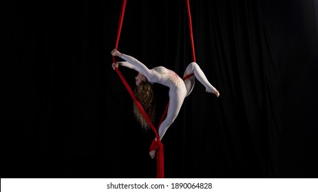 girl gymnast performs exercises with aerial silk isolated on a rough background in contrasting colors. - Shutterstock ID 1890064828