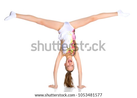 The girl gymnast performs a handstand with bent legs.The concept of childhood, sport, a healthy lifestyle. Isolated on white background.