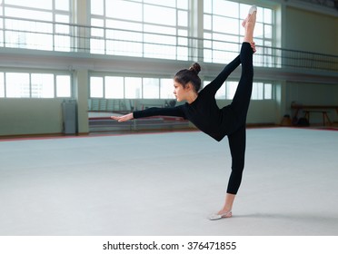 Girl Gymnast In A Sweatsuit Doing Exercises The Balance