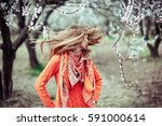 Girl hair develops on the background of blooming trees, positive