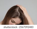 Girl with hair loss problem on grey background
