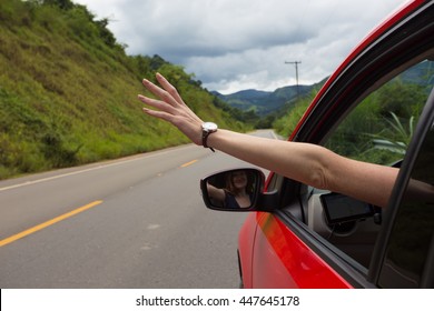 girl hand at the car window on an empty country road