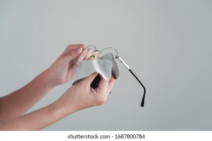 Girl Hand Cleaning Glasses Lens With White Background, Cleaning Glasses Concept.