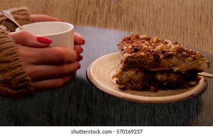 girl hand with cup of coffee and brown cake, vintage background 
