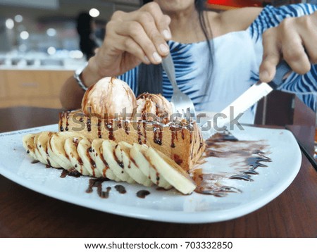 The girl hand is eating Chocolate Brownie Cake.