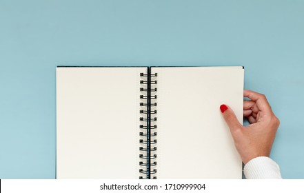 Girl Hand Holding A Blank Notebook. Inspirational Image To Plan Resolutions And Aspirations. Copy Space