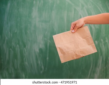 Girl Hand Holding A Brown Paper Lunch Bag 