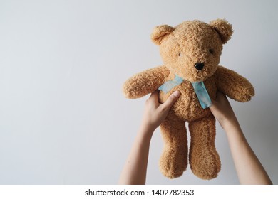 girl holding teddy bears hand