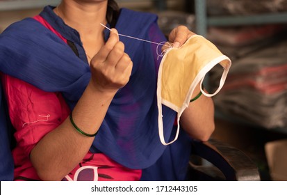 Girl hand Knitting DIY face mask at home to protect from covid-19 or coronavirus pandemic at India - Due to shortage of Medical masks woman in India making masks - Powered by Shutterstock