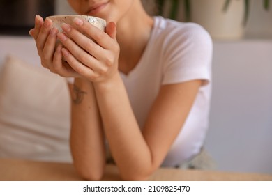 A Girl With Hand Made Mug Sitting At Table