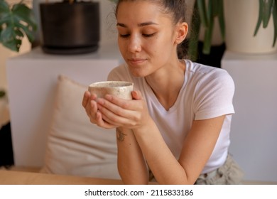 A Girl With Hand Made Mug Sitting At Table