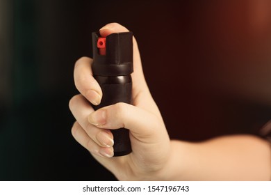 Girl hand is protected by pepper spray. Self defense concept