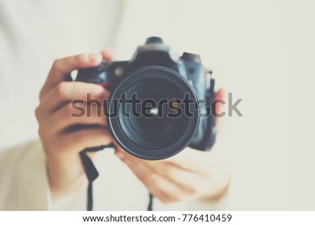Girl hands holding photo camera with vintage color effect, white background, copy space.
