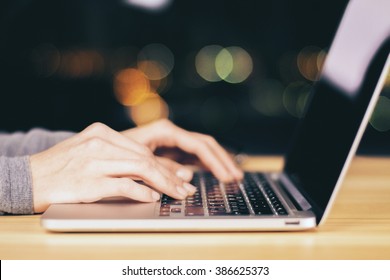 Girl Hands Typing On Laptop On Wooden Table At Night