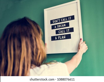 Girl Hanging A Frame On A Green Wall