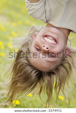 girl hanging upside-down , laughing