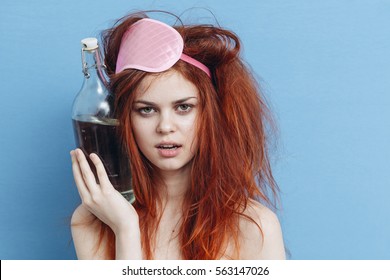 girl hangover on a blue background bottle of alcohol