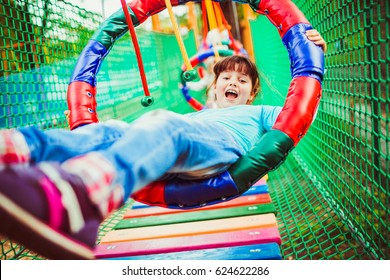 Girl Hangs On The Circle In Adventure Park