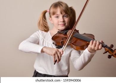 Girl happy looking straight ahead playing the violin. Horizontal composition. Front view. - Powered by Shutterstock